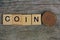 Word made of wooden letters and old brown coin