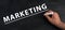 The word marketing is standing on a black chalkboard, handwritten , branding, advertising business