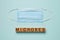 Word Microbes made with wooden cubes and face mask on turquoise background, flat lay