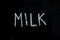 word `milk` drawn on chalkboard.