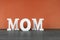 The word mom written in white letters in front of orange background