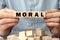 The word MORAL made from wooden cubes. Shallow depth of field on the cubes