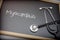 Word Myocarditis written in chalk on a blackboard black next to a stethoscope