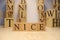 The word nice was created from wooden letter cubes. Cities and words.