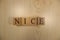 The word nice was created from wooden letter cubes. Cities and words.