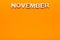 Word November on orange background