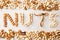 Word NUTS spelled with various nuts on stona background. Assorted mixed nuts