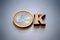 The word OK made of wooden letters and euro coins on a gray background. Monetary concept of financial investments or transactions