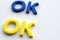 The word Okay which is written by blue and yellow letters