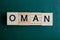 Word oman made of small gray wooden letters