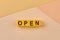 The word OPEN written on yellow cubes close up. Business opening concept.