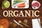 Word ORGANIC in wooden letters with many cooking ingredients