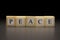 The word PEACE written on wooden cubes, isolated on a black background