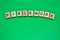 Word piecework. Top view of wooden blocks with letters on green surface