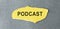 word PODCAST on a yellow piece