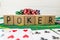 The word poker on wooden cubes, poker chips with playing cards on the green casino table