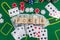 The word poker on wooden cubes, poker chips with playing cards on the green casino table