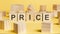 the word price written on wooden cubes on yellow background