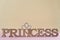Word Princess abstract wooden letters. Pink background with sparkling crown.