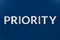 The word priority laid with silver letters on blue color surface