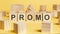 the word promo written on wooden cubes on yellow background