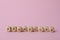 Word Promocode made of wooden cubes with letters on pink background, space for text