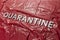 The word quarantine laid with silver letters on red crumpled plastic film background in diagonal perspective
