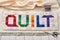 The word quilt sewn from colorful square and triangle pieces of fabric