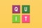 The word quit on colorful square blocks on yellow background. To quit smoking, quitting a job resignation or quitting something