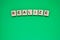 Word realize. Top view of wooden blocks with letters on green surface