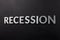 the word recession laid with white brushed metal letters on flat black surface