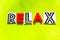 Word relax of black and red letters on a green background