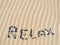 Word relax written in sand