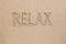 The word relax written on the sand