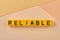 The word reliable written on yellow cubes close up.