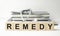 The word REMEDY is written on bright wooden cubes and stethoscope