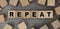 The word REPEAT made from wooden cubes. Conceptual photo