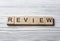 Word REVIEW on wood abc cubes at wooden background.