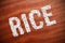 The word rice on a wooden surface.