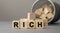 Word RICH made with cube wooden block on a desk