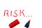 The word `risk` written in red marker on a white background.