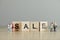 Word `sale` spelled out with wooden tiles