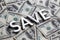 The word SAVE laid with white metal letters on the americal dollar banknotes background with selective focus