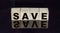 Word Save on wooden cubes on black mirrored background with reflection. Money saving and tax savings