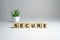 The word Secure, alphabet on wooden cubes on white background. Bricks background, blank copy space, vintage minimal style.