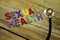 Word SEXUAL HEALTH colorful wooden alphabet letters set and stethoscope on wooden background. Healthcare and medical concept