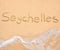 The word Seychelles written in the sand on beach