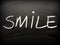 The word SMILE written on a Blackboard