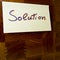Word solution written on a yellow postit attached on a wood panel - for conceptual use