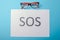 Word SOS written on paper